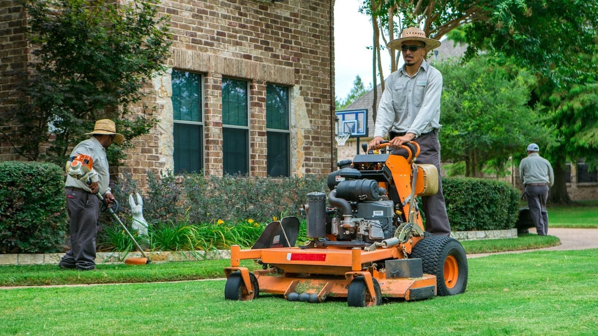 Professional gardener mowing a perfectly manicured lawn