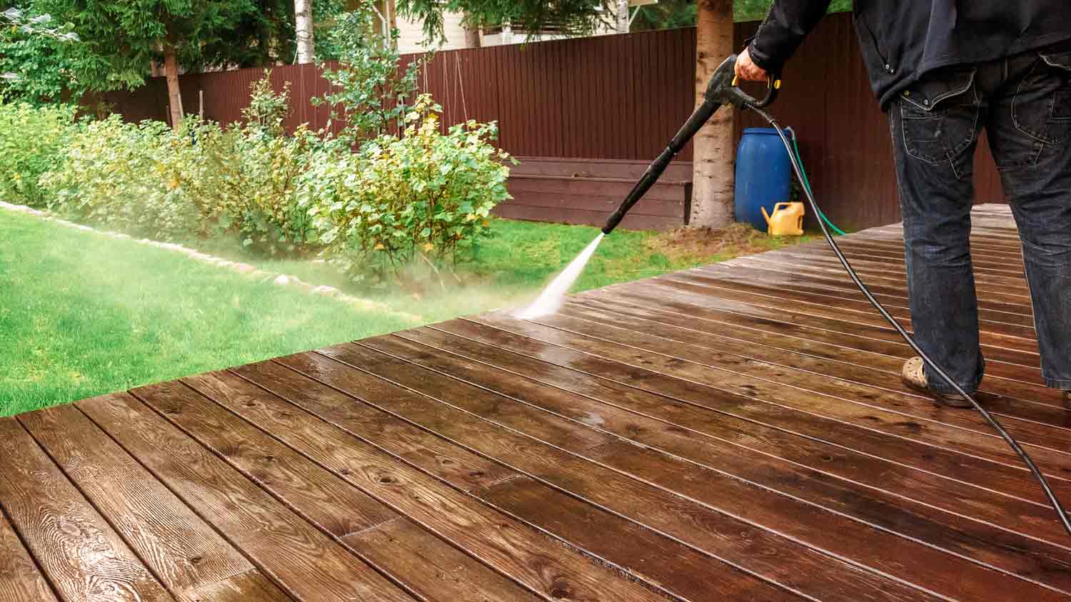 Worker pressure washing a patio area